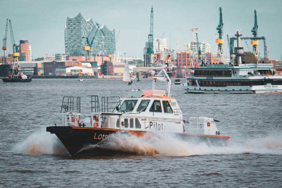 Ein Lotsenboot fährt auf der Elbe vor der Hamburger Hafenkulisse mit Elbphilharmonie